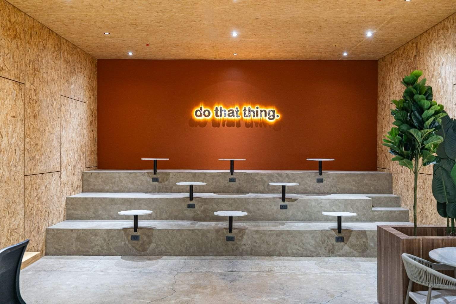 The amphitheater's tiered seats facing an orange wall