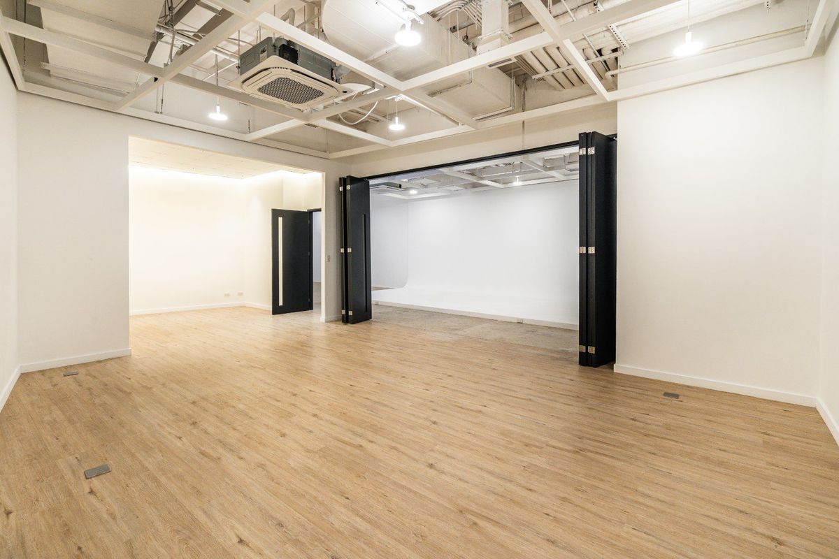 An open studio room with wooden floors and folding doors